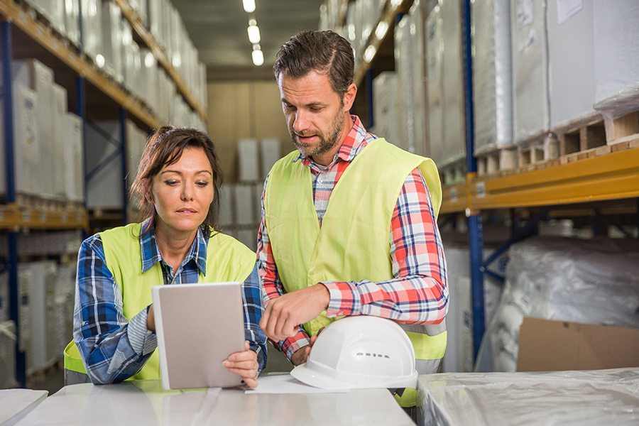 Two employee are havinga discussion while looking at the tablet.