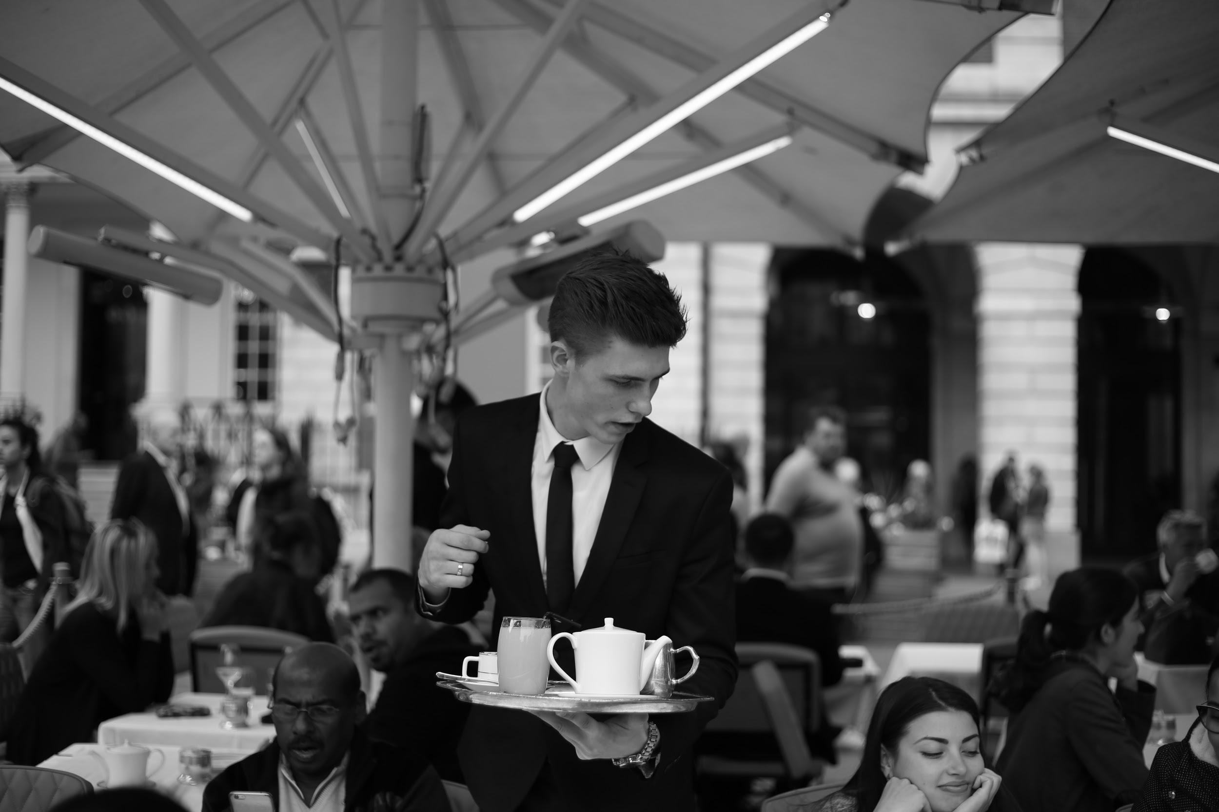 一个拿着咖啡的侍者，黑白图像