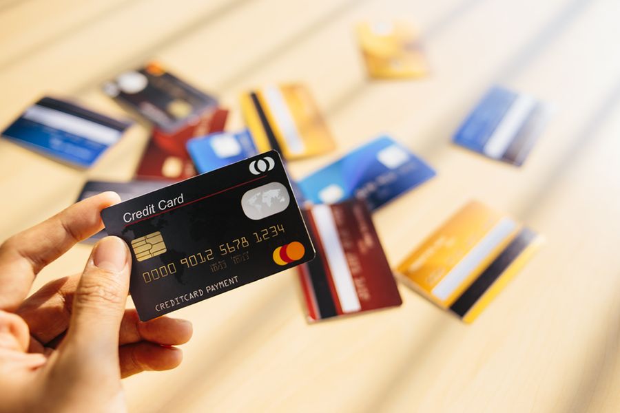 A hand holding a black credit card.