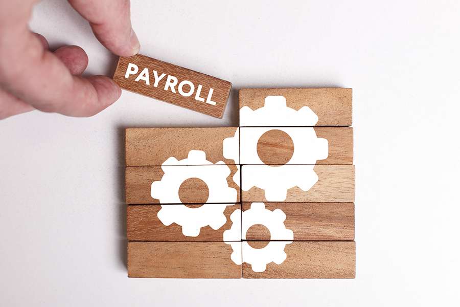 Stacked rectangle wood with printed payroll and gears.