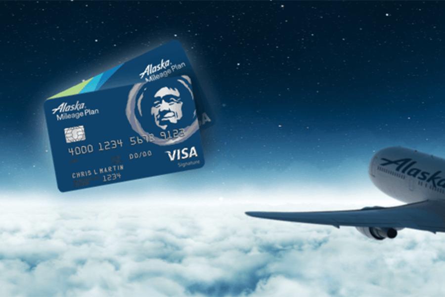 两张阿拉斯加航空Visa商务信用卡和一架飞机。