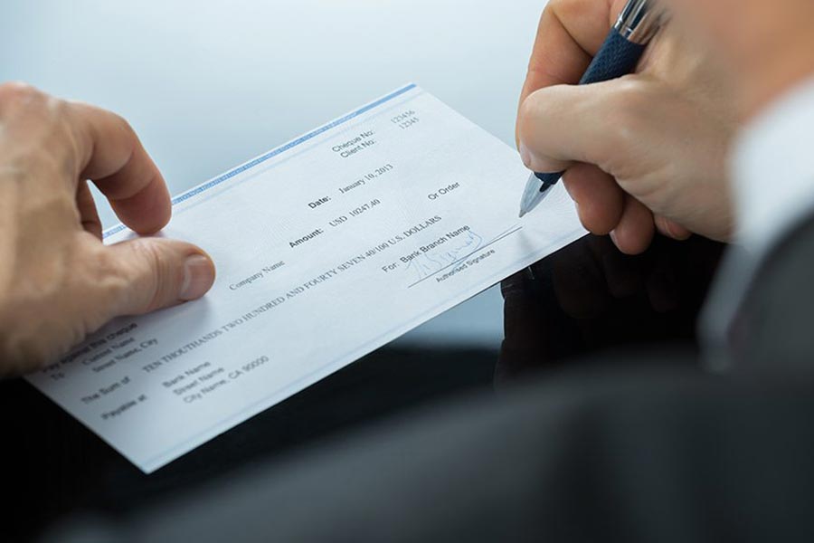 Businessman signing a check.