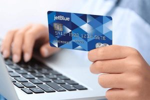 男子手里拿着捷蓝航空的信用卡，用于网上购物付款。