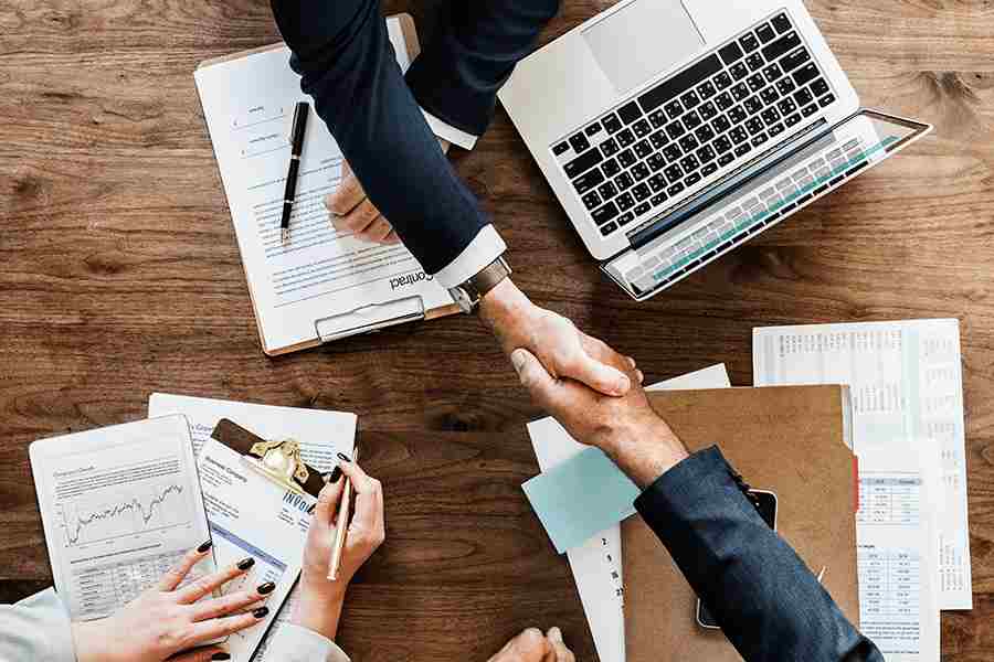 Man and woman shaking hands, act of closing a successful deal.