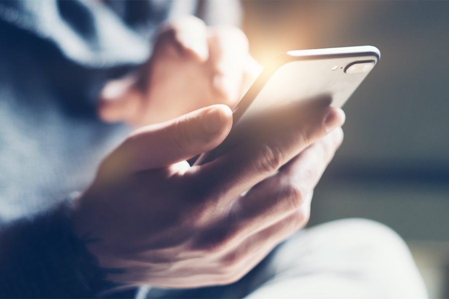 close up of a man holding a phone