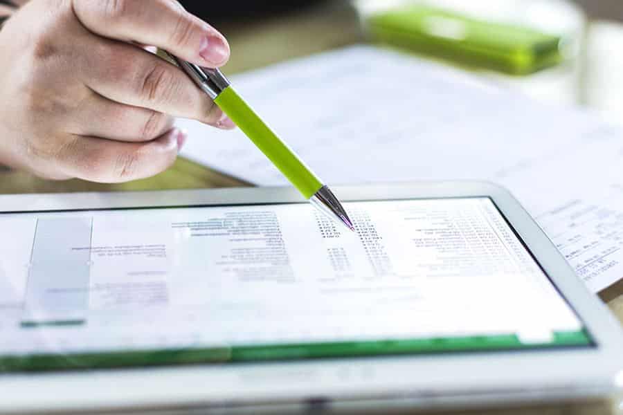 hand holding pen pointing at tablet