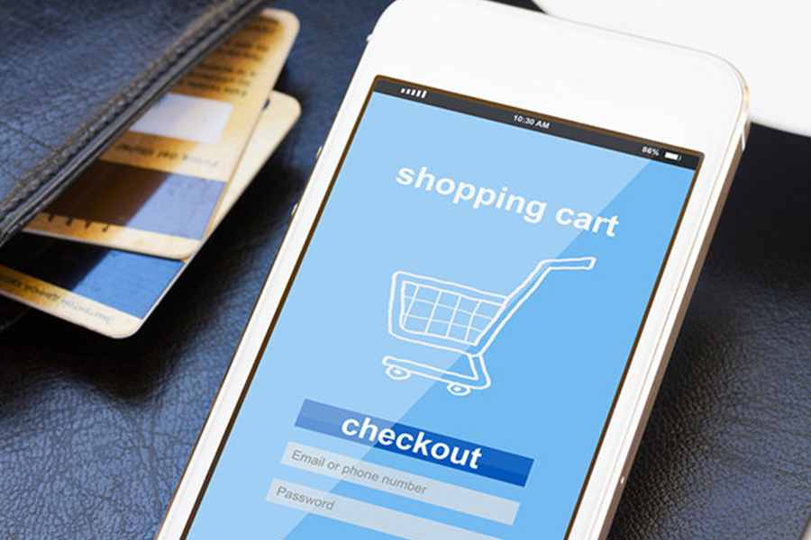 A shopping cart logo and a login screen on a mobile phone with a wallet and card beside it.
