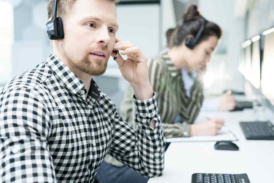 男性呼叫中心座席，使用VoIP蓝牙耳机。