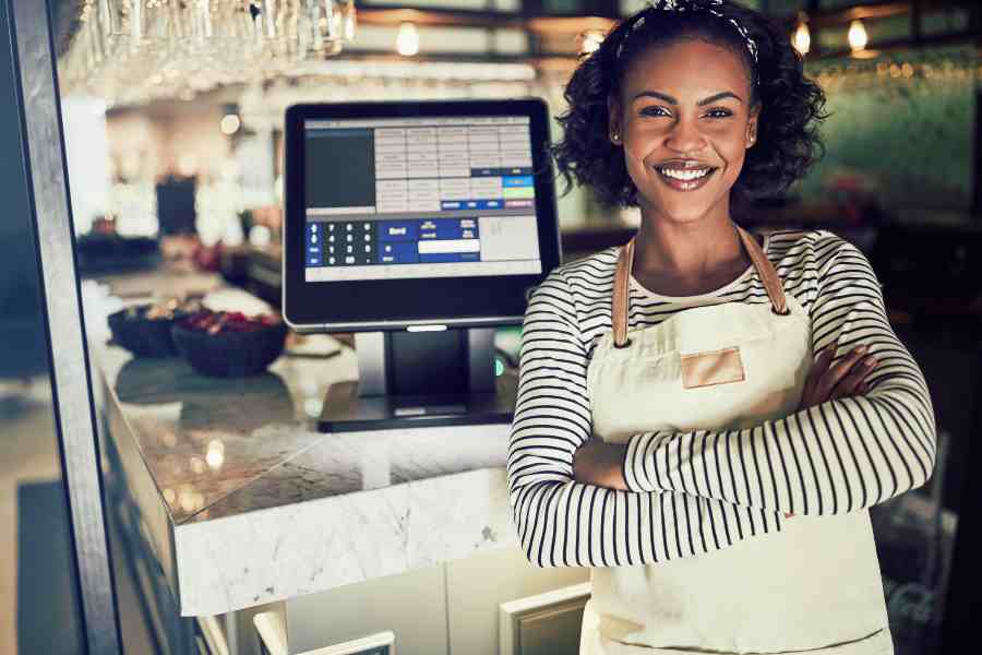 Showing a woman at the counter smiling at the camera.