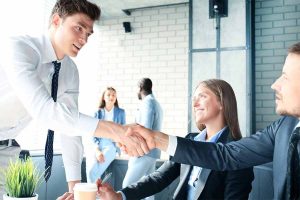 Two young businessman shake hands.