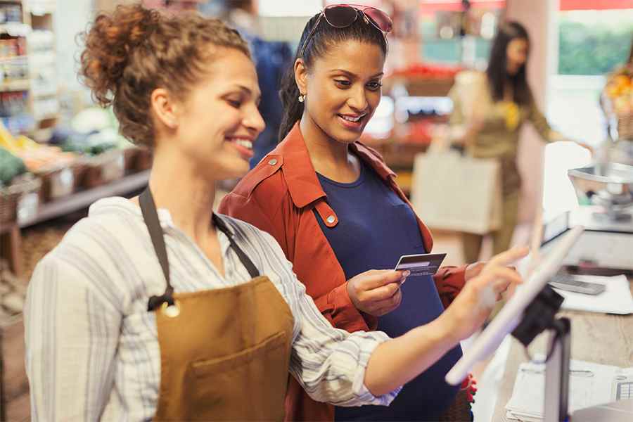 Cashier staff and a shopper transacting.