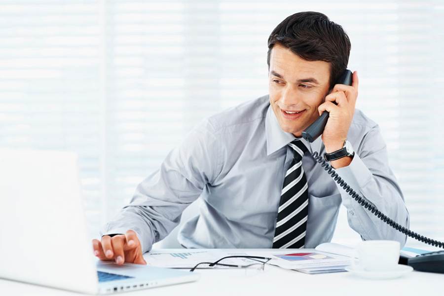 Businessman having a call while working on his laptop