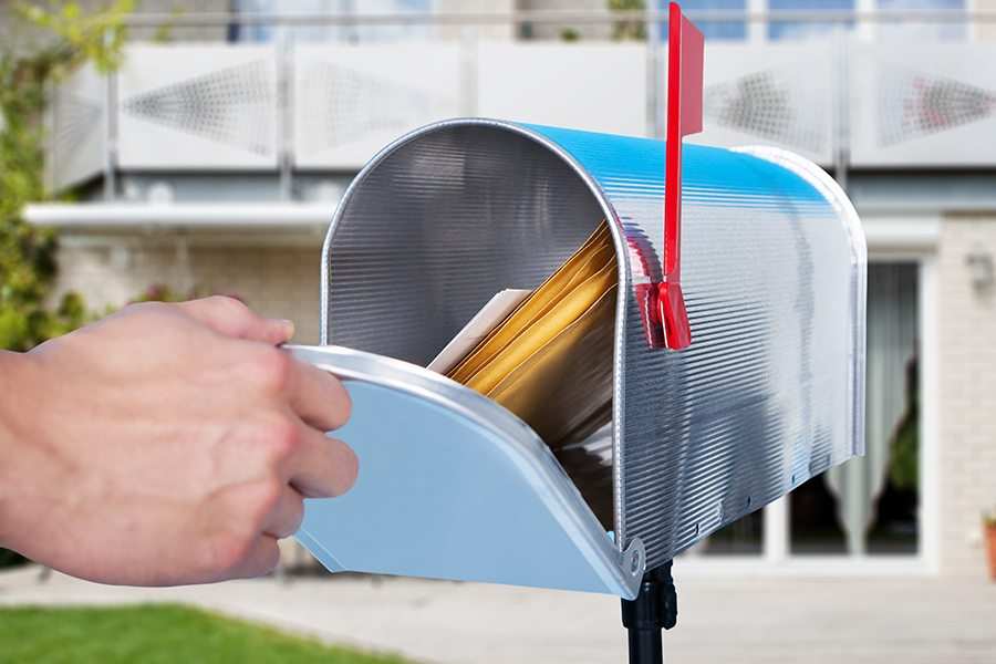 Man's hand opening the mailbox