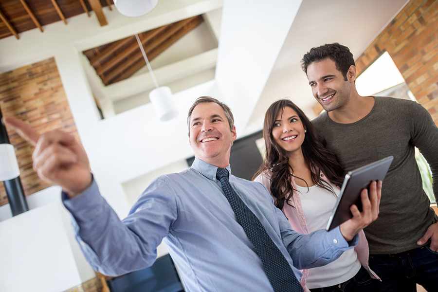 Male realtor showing new house to couple