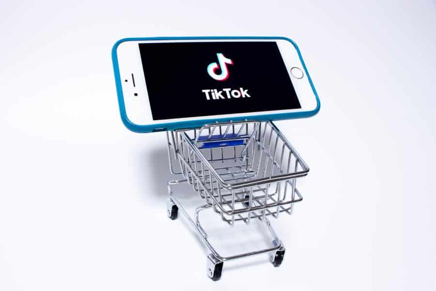 展示了一个迷你购物车，上面有一部手机，屏幕上有一个TikTok的标志。