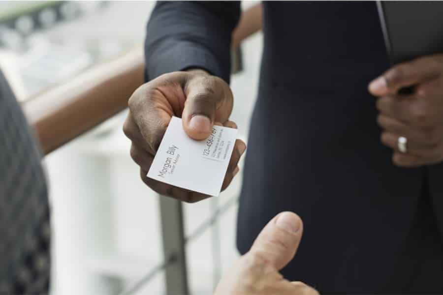 Businessman giving out his printed business card.