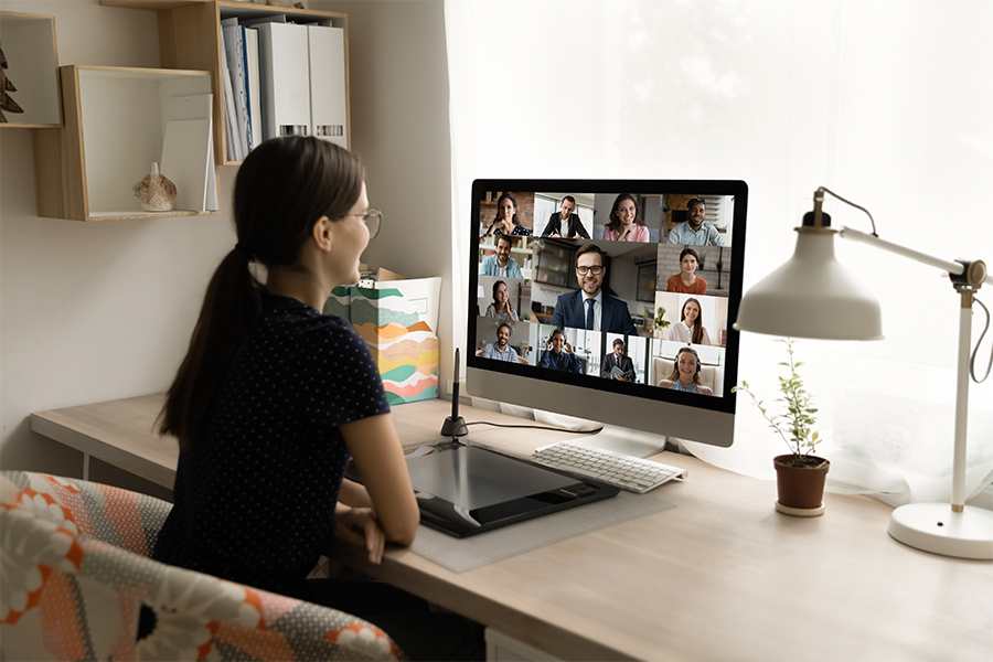 Back rear view happy millennial female employee looking at computer monitor, holding online video call negotiations meeting.