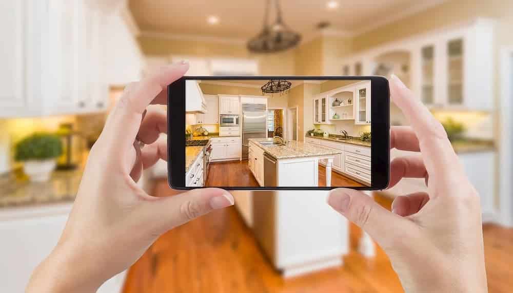 手持智能手机显示厨房照片的截图