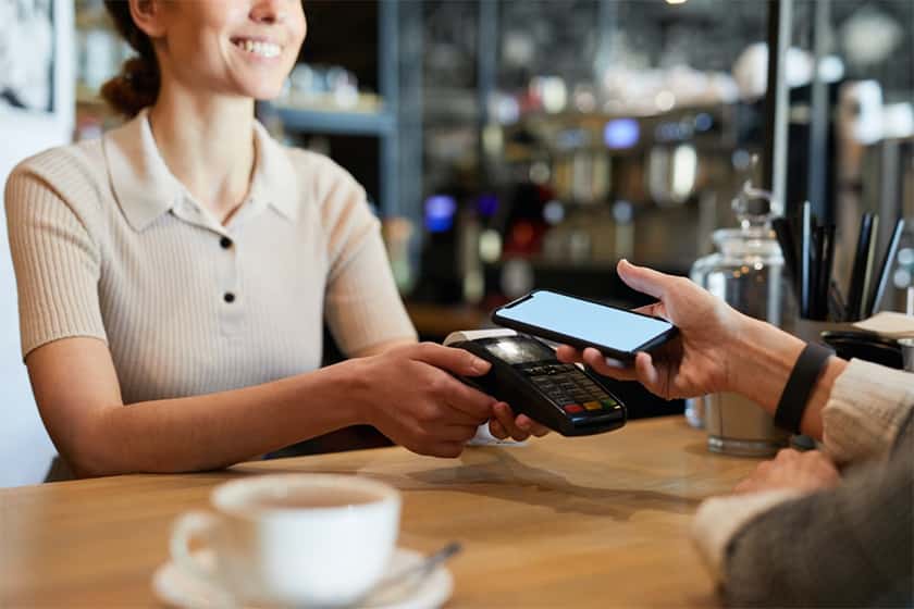 在咖啡厅通过智能手机使用近场通信技术支付账单