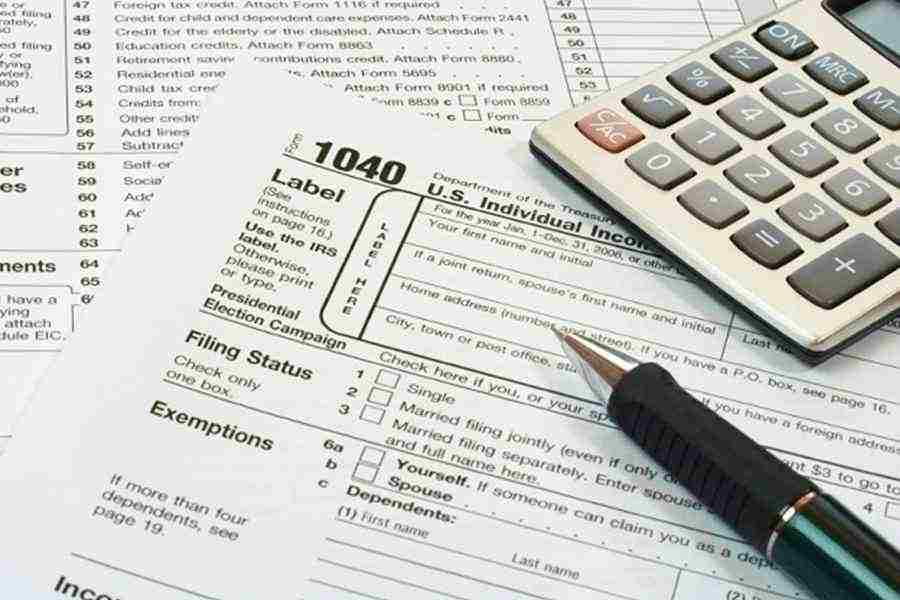 Showing form 1040 with calculator and pen.