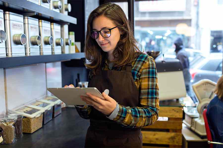 Young woman wearing glasses holding a digital tablet.