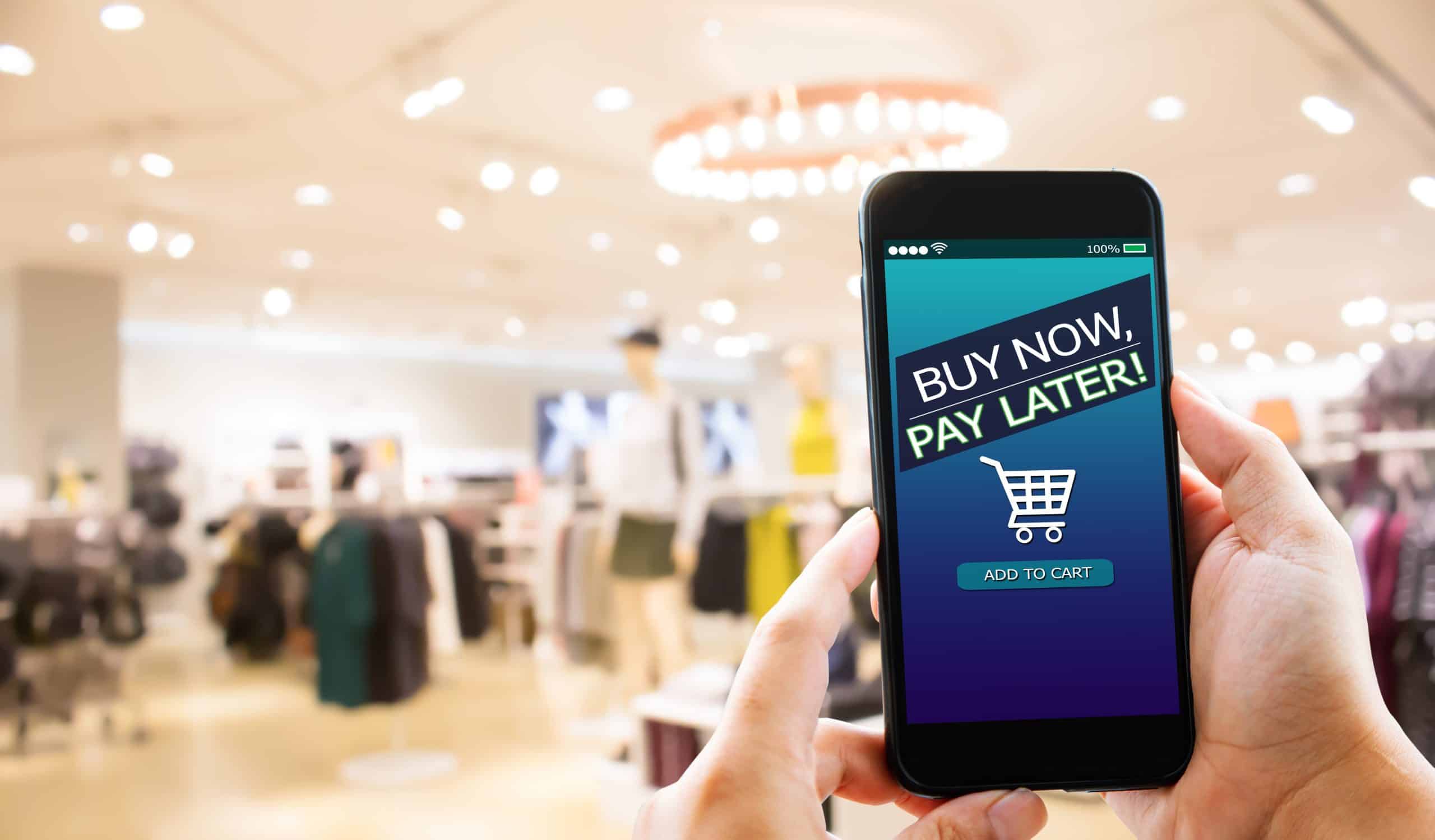 在手机屏幕上显示一个顾客在商店里“现在买，以后付款”。