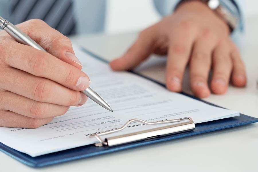 Close up shot of a man's hand filling up a form.