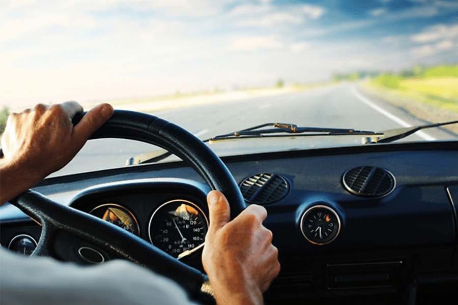 近距离拍摄的man's hand gripping steering wheel while driving.