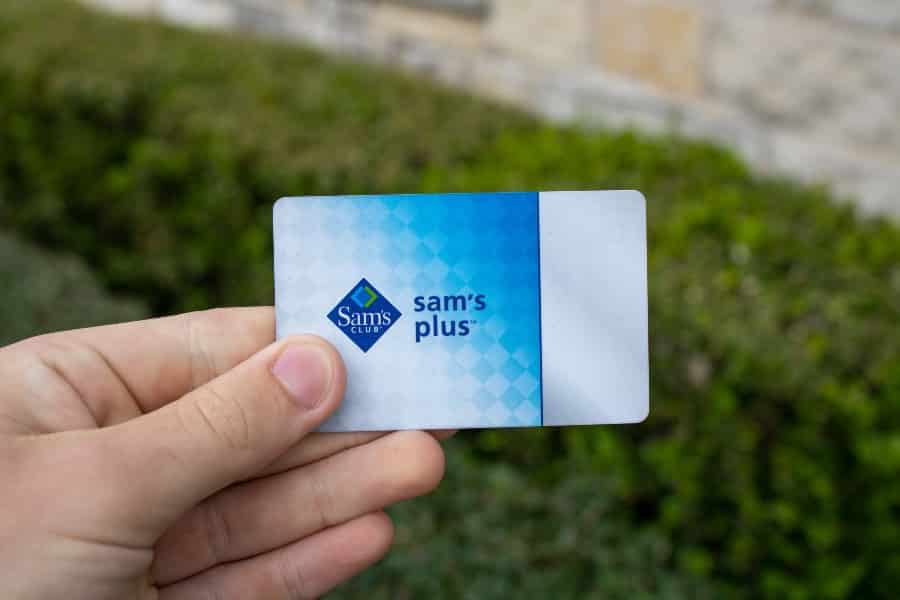 一只手拿着山姆会员商店会员卡，它可以让用户进入山姆会员商店的仓库购物，奖励，廉价的食物广场。
