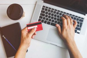 一个人手里拿着一张信用卡在网上购物。