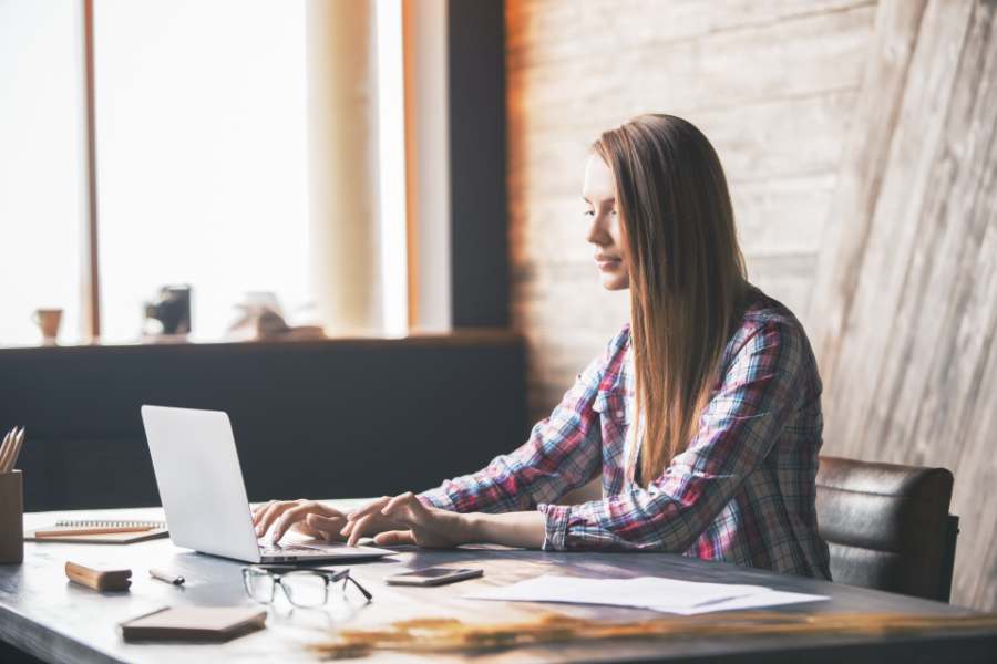 Young woman taking real estate classes online using her laptop