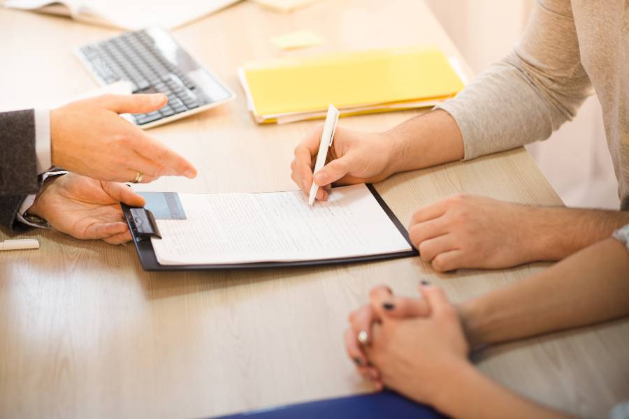 The Businessman and the clients sign the sales contract.