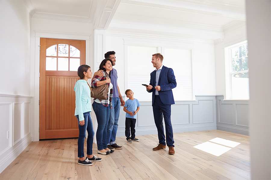 Happy family checking the house with the real estate agent.