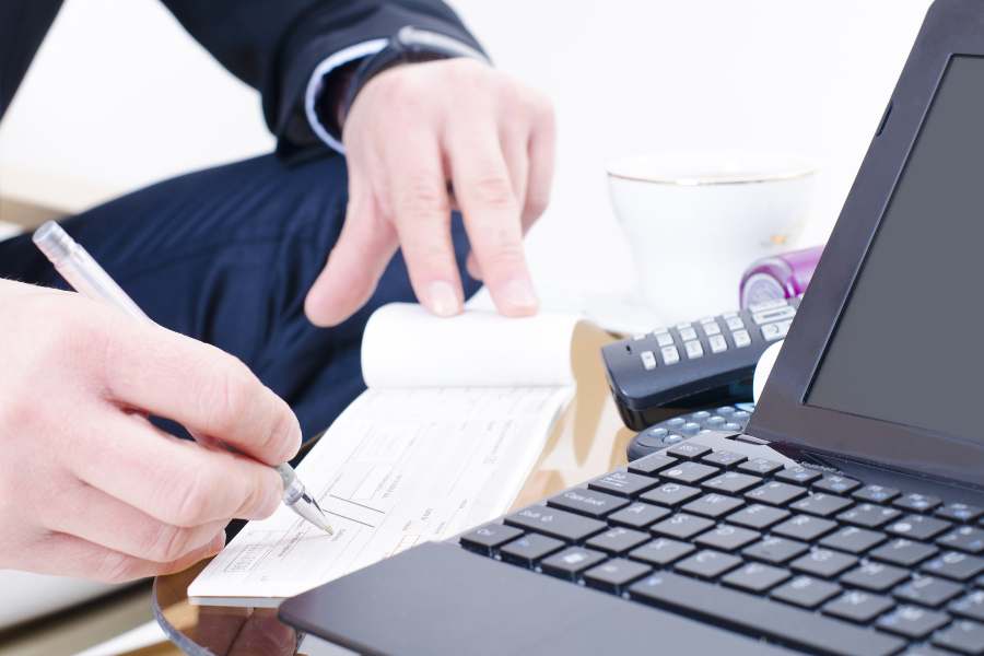 Businessman about to write in a check.