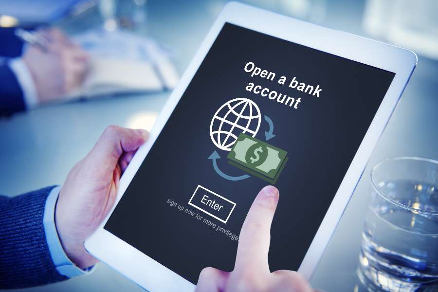 Man opening a bank account using the tablet he is holding.