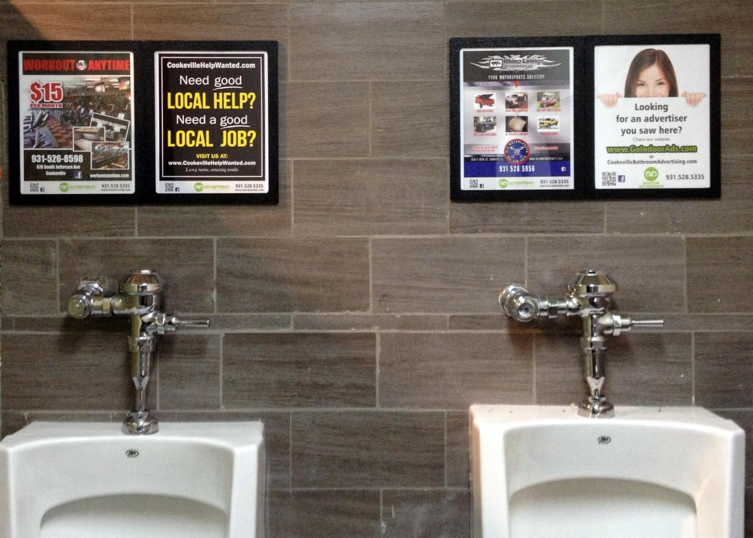 A photo of advertisements in a restaurant bathroom.
