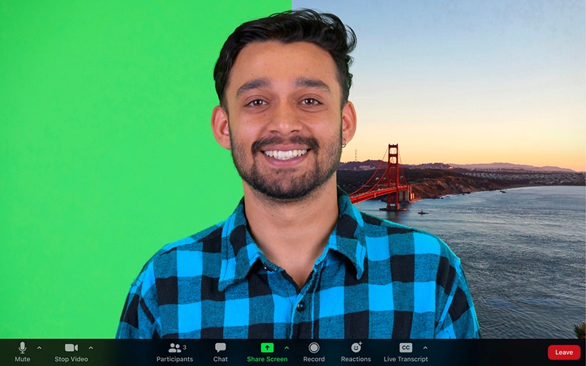 An ongoing Zoom meeting showing a man smiling with two different backgrounds: plain green on the left side of the screen and a Golden Gate Bridge image on the right