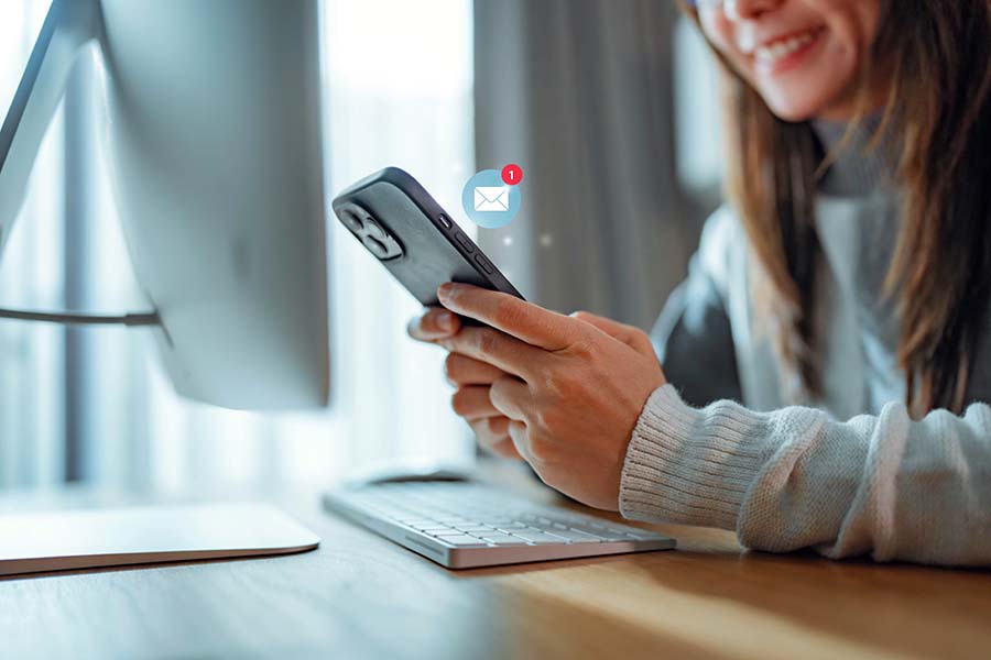 A woman using smartphone with 1 new email alert sign icon.