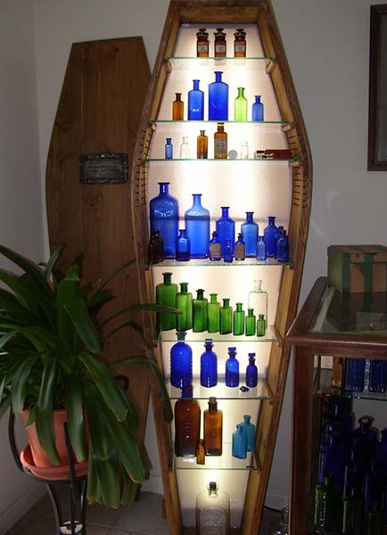 Bottles displayed in a casket-shaped shelf.