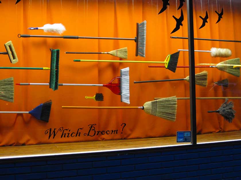 Several brooms arranged in a window display.